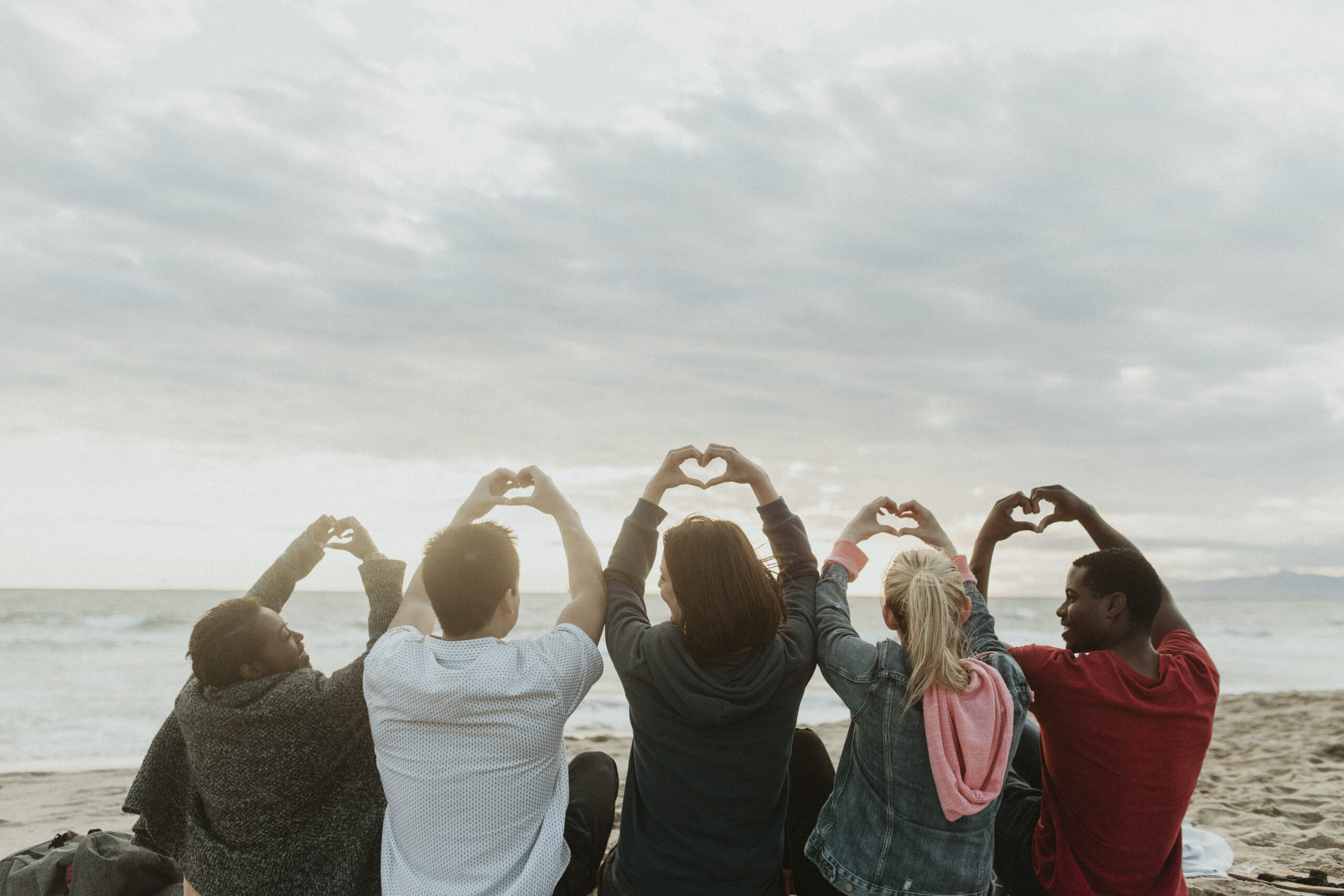 Contact information 6 Friends making love heart hands at the beach