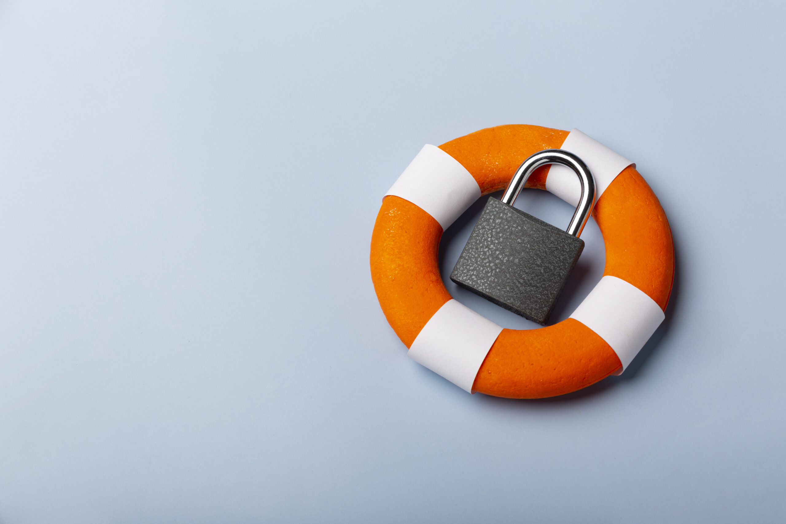 Contact information 4 Photo of a lifering with a locked padlock resting inside it on a grey coloured background